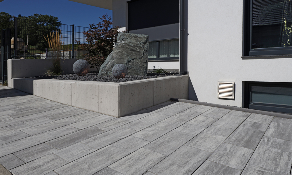 Cadea B30 VG4 gránitszürke árnyalt A Cadea B30 VG4 gránitszürke árnyalt térkövek alakítják a modern bejáratot, a Friedl Steinwerke térköveivel.