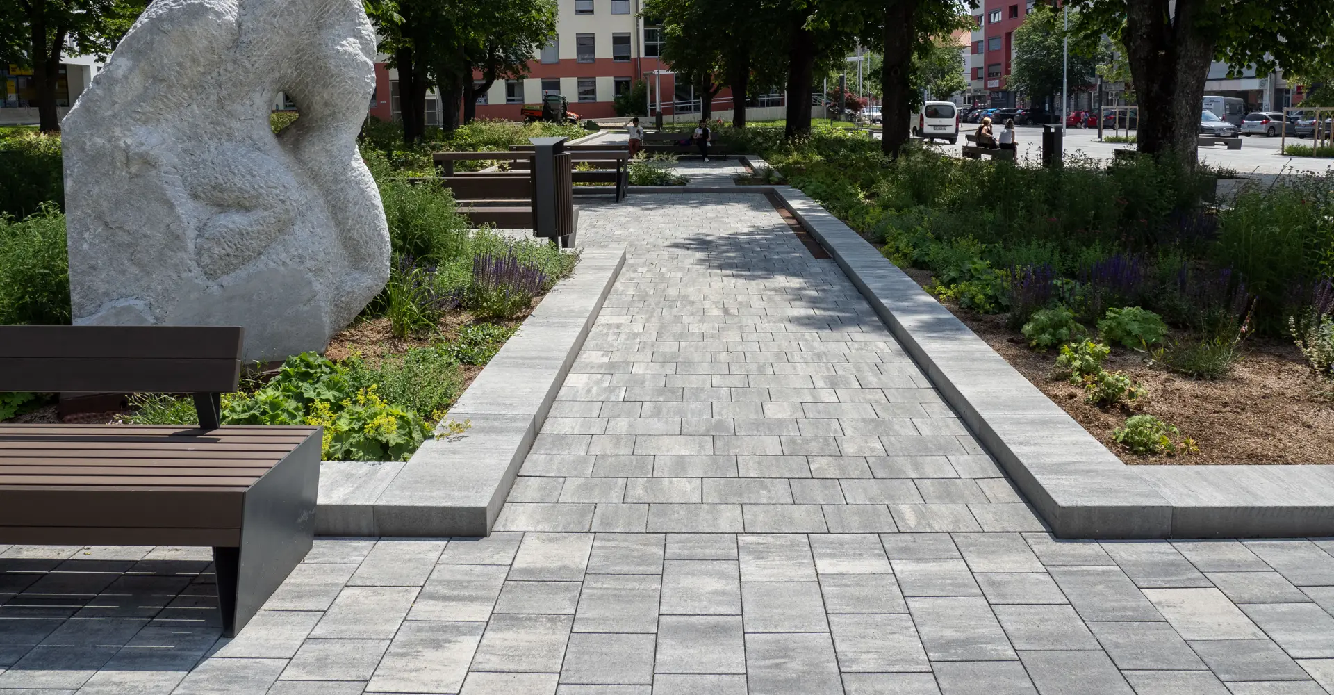 Sétány padokkal és kőszoborral az oberwarti városi kertben; Magnum és Arret B25 VG4 térkő, gránitszürke árnyalt, Friedl Steinwerke.