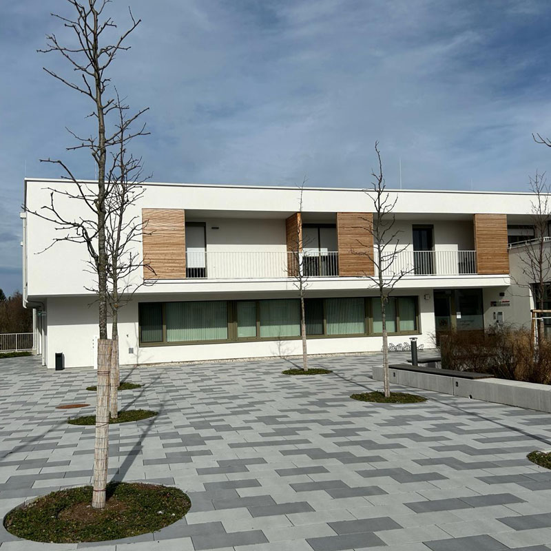 Gemeindezentrum Draßmarkt Linea VG4 térkő, platina világos és sötét árnyalt Draßmarkt központ előtti tér Linea VG4 térkővel, platina világos és sötét árnyalatban, harmonikus hatás, Friedl Steinwerke.