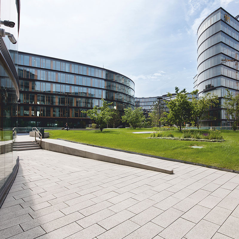 Gyalogút zöldfelület mellett Largo burkolólap nemeszúzalék fehér-fekete az Erste Group/Erste Campusnál Friedl Steinwerke.