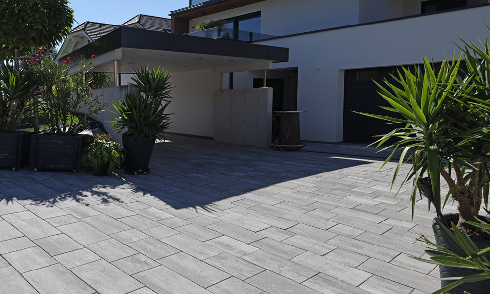 Cadea B30 VG4 gránitszürke árnyalt A Cadea B30 VG4 gránitszürke árnyalt térkövek formálják a modern bejáratot, Friedl Steinwerke kövekkel.