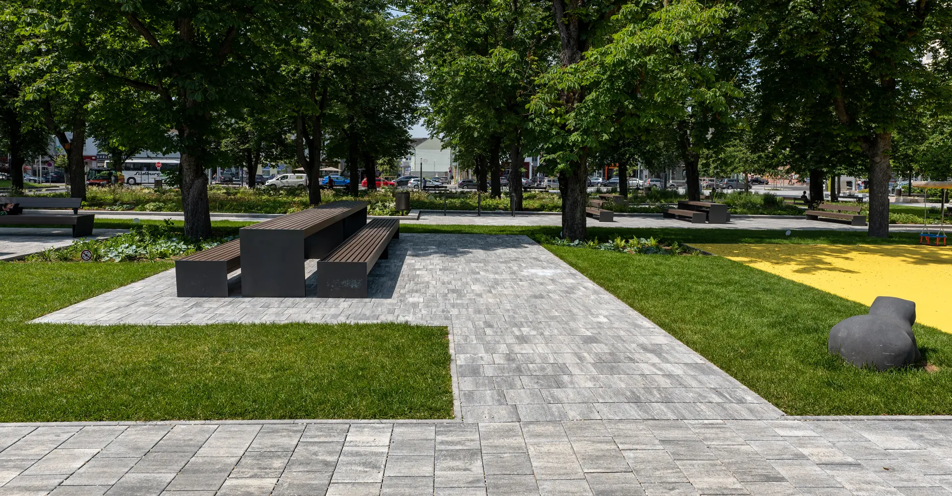 Ülőfelületekkel és sétányokkal kialakított városi kert, Oberwart; Magnum és Arret B25 VG4 térkő, gránitszürke árnyalt, Friedl Steinwerke.