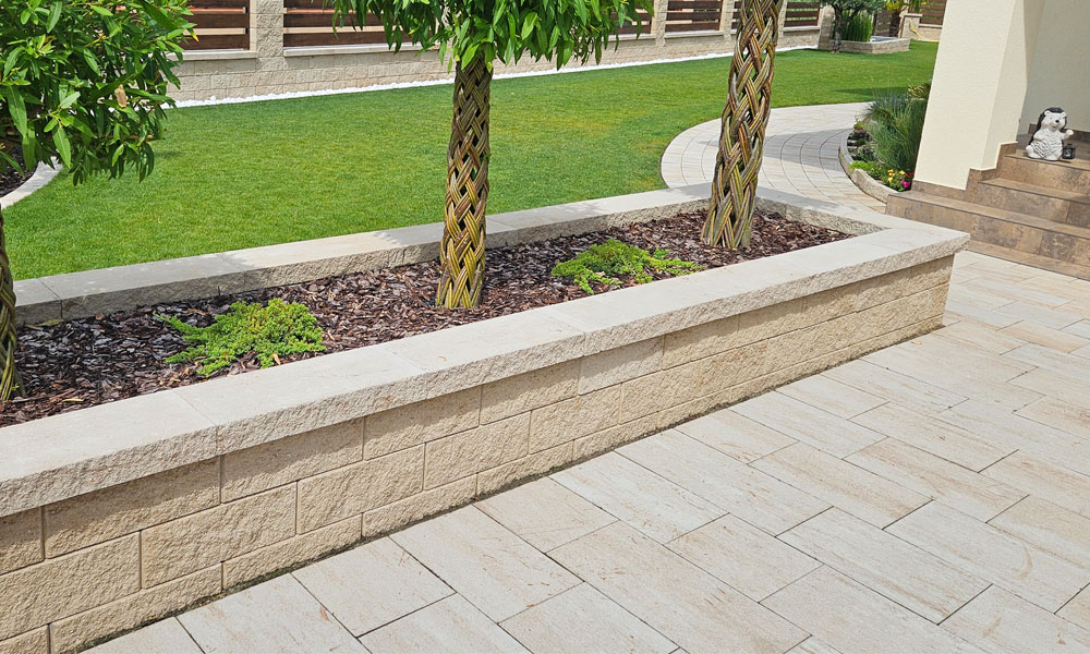 Cadea B30 kalkstein-schattiert von Friedl Steinwerke, im Eingangsbereich verlegt mit klarer Linienführung. Dahinter wurden Faro Zaunsteine als Mauer umgesetzt – gemeinsam eine abgestimmte Gestaltungslösung. Cadea B30 kalkstein-schattiert von Friedl Steinwerke, im Eingangsbereich verlegt mit klarer Linienführung. Dahinter wurden Faro Zaunsteine als Mauer umgesetzt – gemeinsam eine abgestimmte Gestaltungslösung.