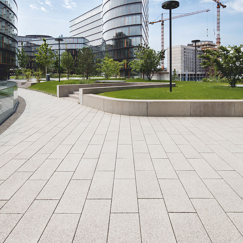 Gyalogút zöldfelület mellett Largo burkolólap nemeszúzalék fehér-fekete az Erste Group/Erste Campusnál Friedl Steinwerke.