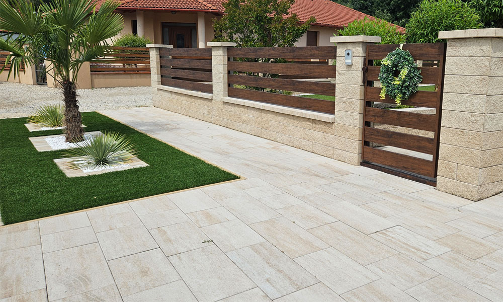 A Friedl Steinwerke Cadea B30 VG4 térkő mészkő árnyalt színben, hosszanti árnyalással, beépítve egy rendezett kocsibeállóba. A Friedl Steinwerke Cadea B30 VG4 térkő mészkő árnyalt színben, hosszanti árnyalással, beépítve egy rendezett kocsibeállóba.